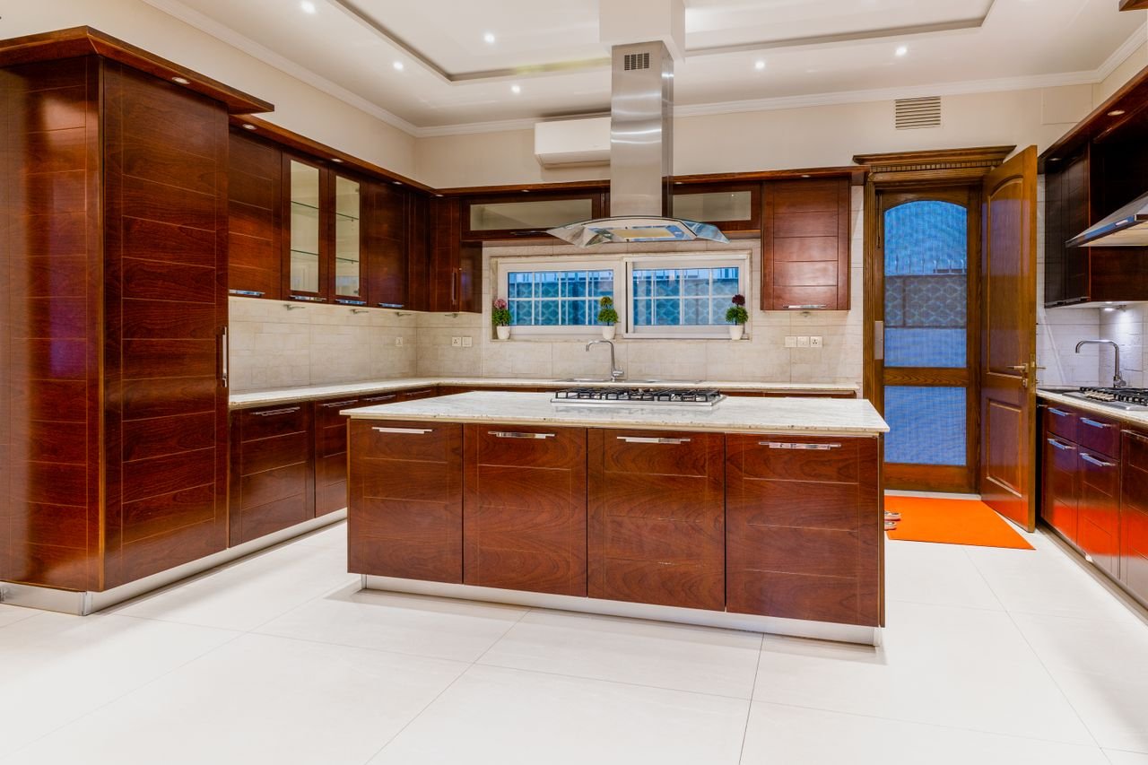 Home Modern kitchen with dark wood cabinets and marble countertops, emphasizing elegant interior design.