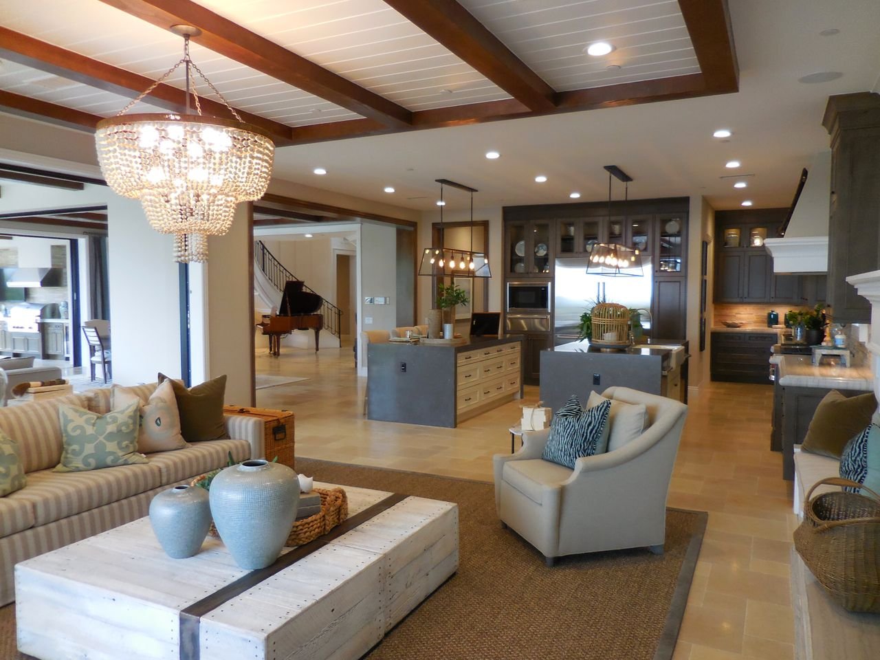 The Art of Drawing Readers In: Your attractive post title goes here Spacious living room with elegant decor and an open kitchen area, featuring a chandelier and comfortable furnishings.